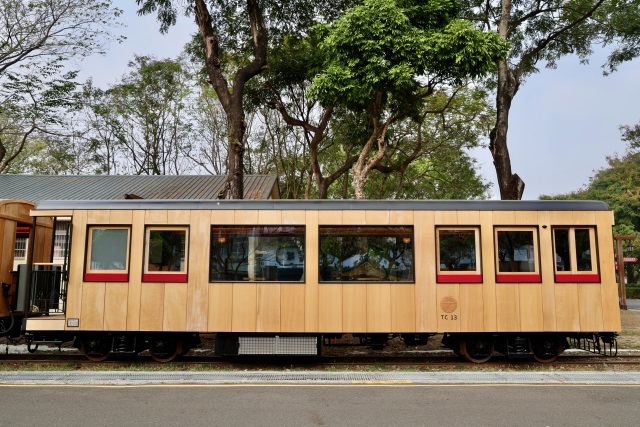 02-車廂外觀採用大片式的台灣檜木板材，搭配深邃的黑色窗框，並在車身側面以經典紅色點綴。